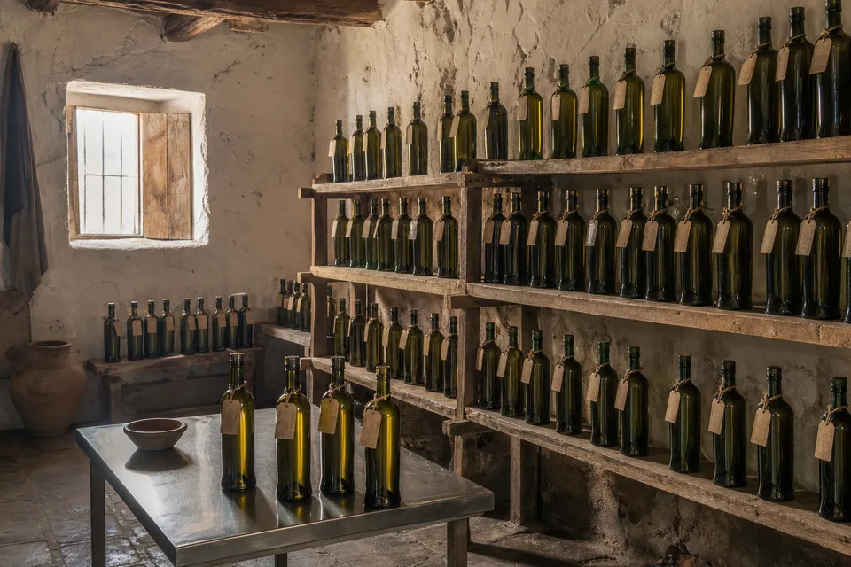 Botellas de aceite guardadas en estanterías, cada una con su etiqueta